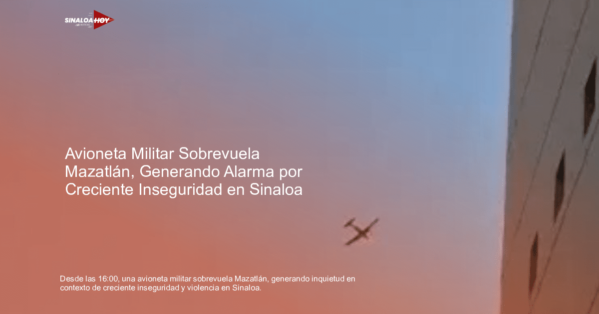 Avión militar volando en el cielo azul de Mazatlán con un edificio visible a la derecha