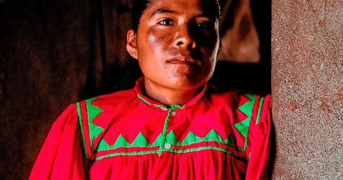 Corredor con camisa roja y detalles verdes en carrera de 100 km en Hong Kong