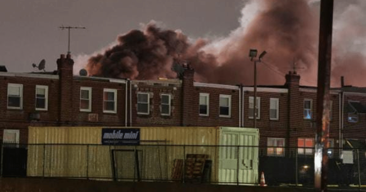 Paisaje urbano nocturno en Filadelfia con edificios y humo en el cielo.