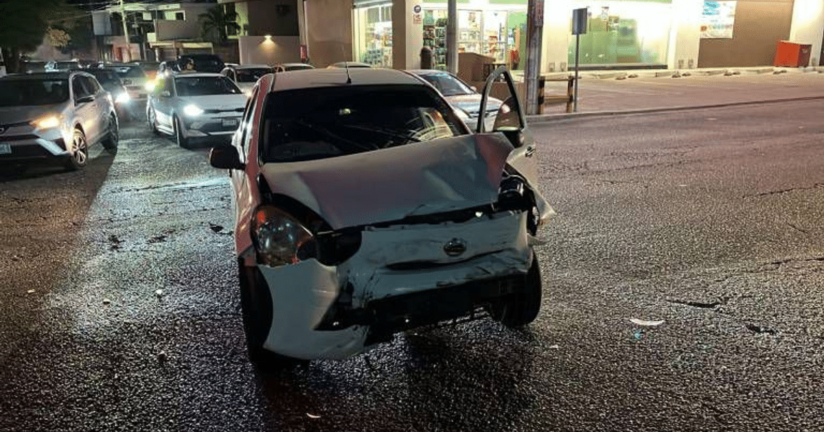 Vehículo Honda azul dañado tras accidente en Culiacán, con puerta abierta y calle mojada.