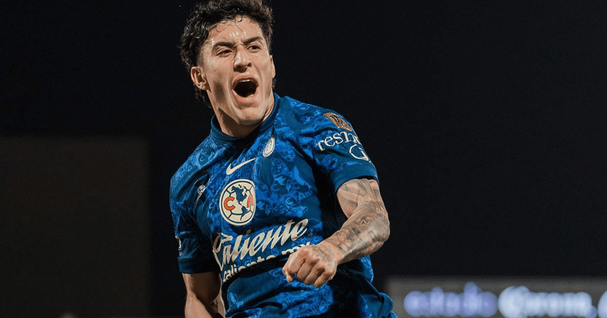 Futbolista celebrando gol con camiseta azul y detalles en blanco