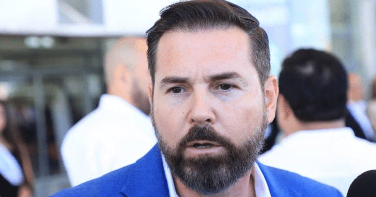 Hombre con barba en un evento social, vestido con saco azul, relacionado con el impacto de aranceles de EE.UU. en México.