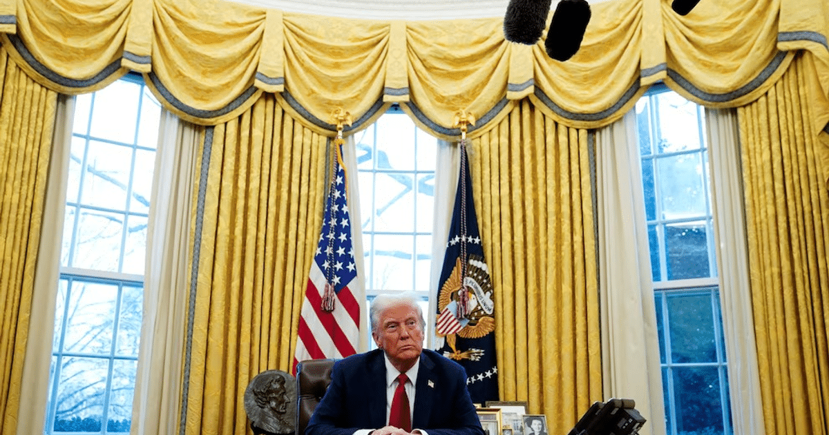 Donald Trump en el Despacho Oval con banderas y micrófonos, relacionado con la implementación de aranceles.