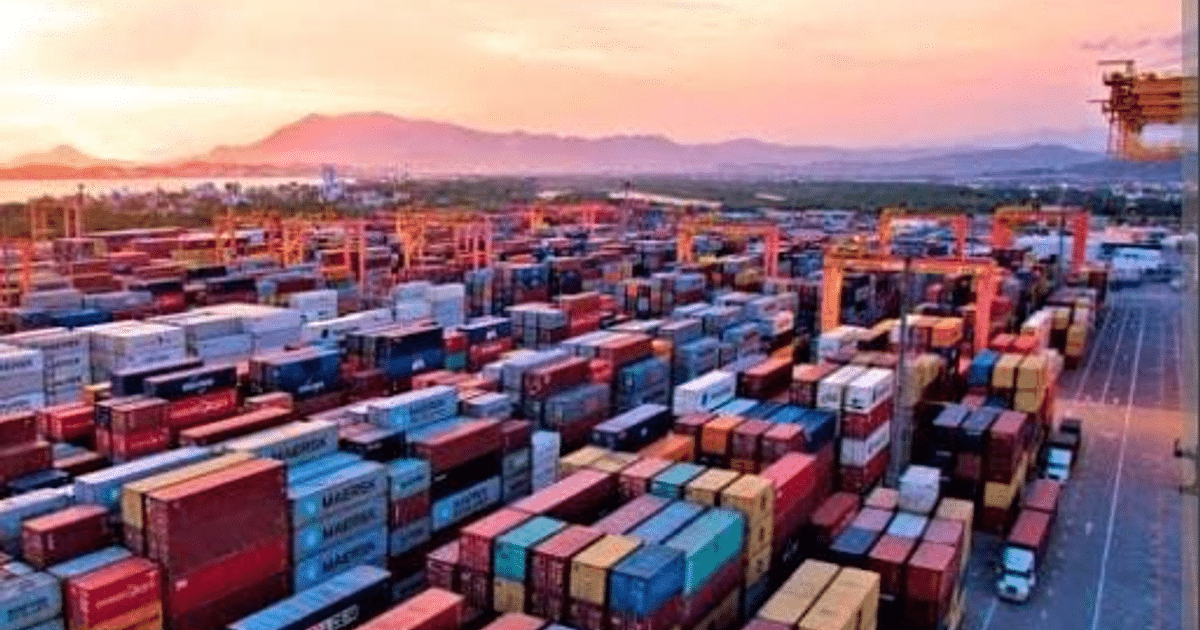 Puerto de carga con contenedores y grúas al atardecer, simbolizando el comercio internacional y las nuevas tarifas de importación de EE.UU.