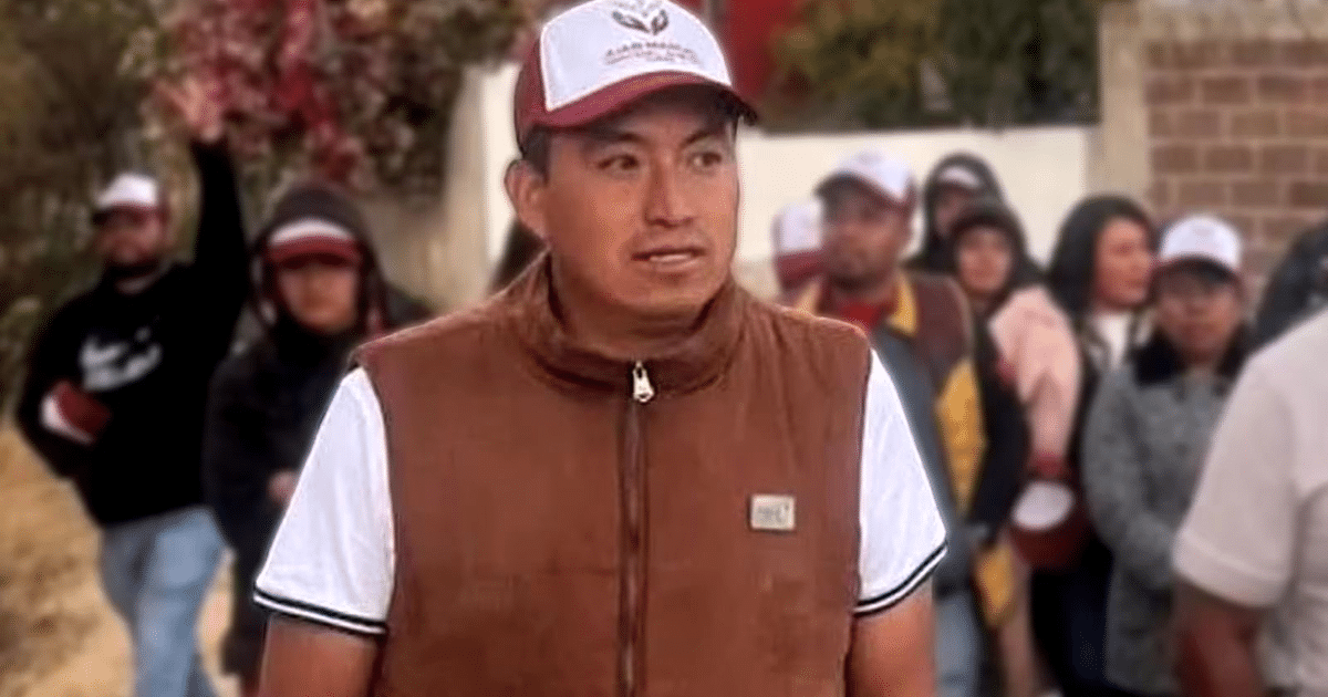 Hombre con chaleco marrón y gorra en evento al aire libre en San Pedro Zacachimalpa.