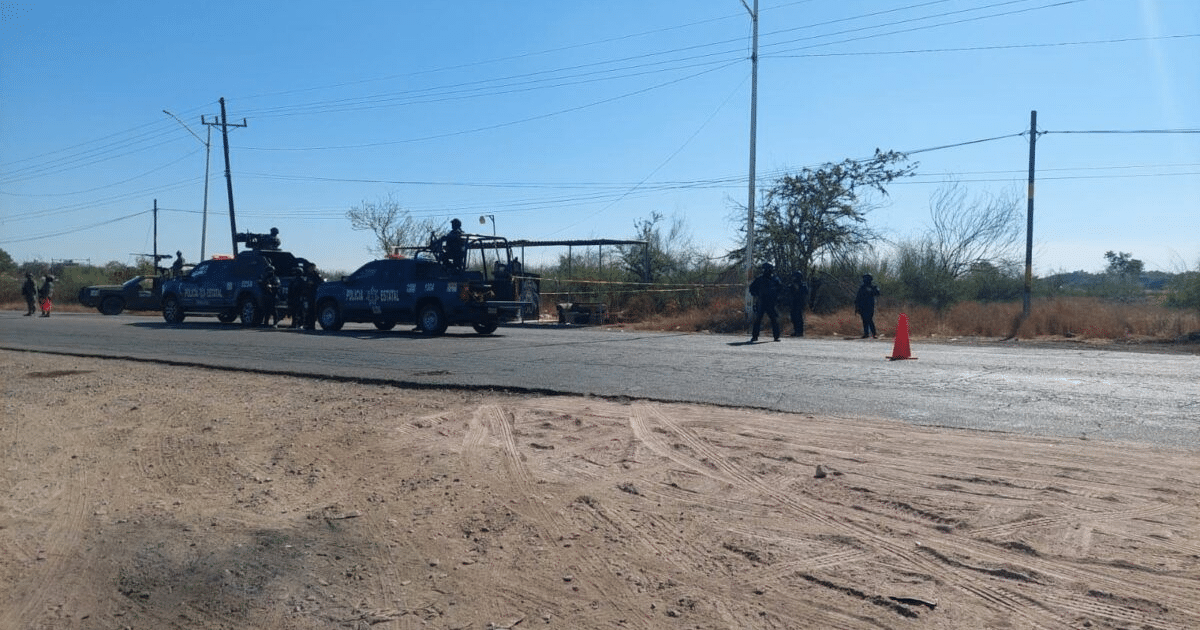 Vehículos de la policía estatal y agentes en un operativo en carretera semiárida de Culiacán.