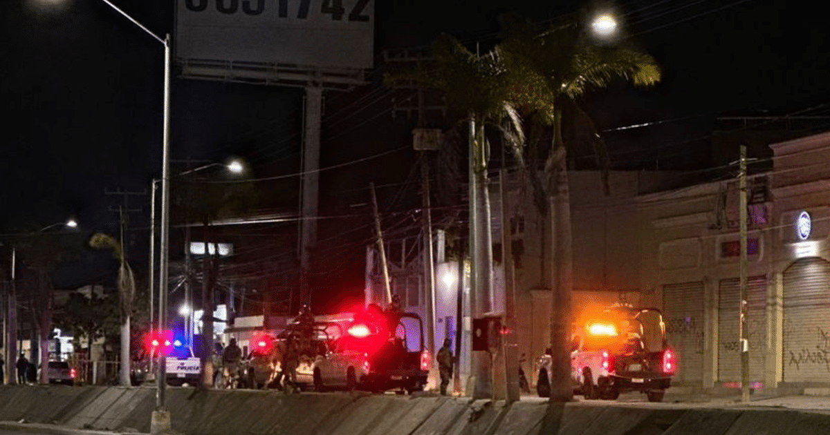 Vehículos de policía con luces de emergencia en Mazatlán durante la noche.
