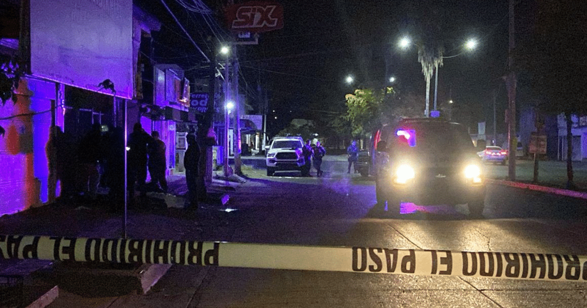 Calle nocturna en Culiacán con vehículos y cinta de seguridad