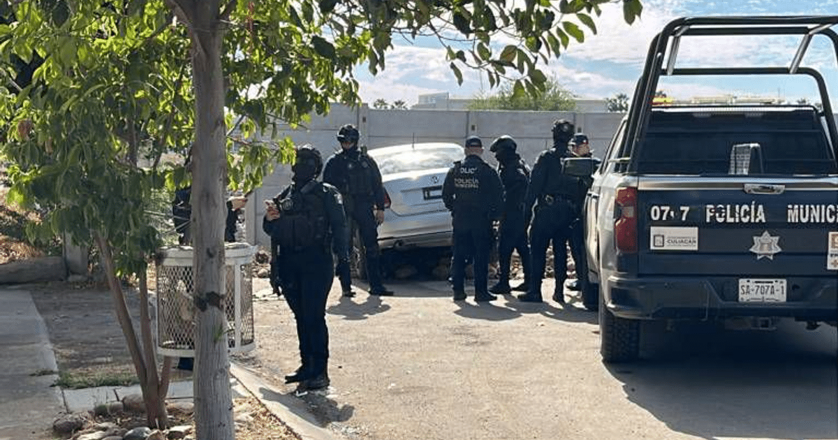 Policías investigan un vehículo incrustado en el suelo tras un ataque armado en Culiacán.