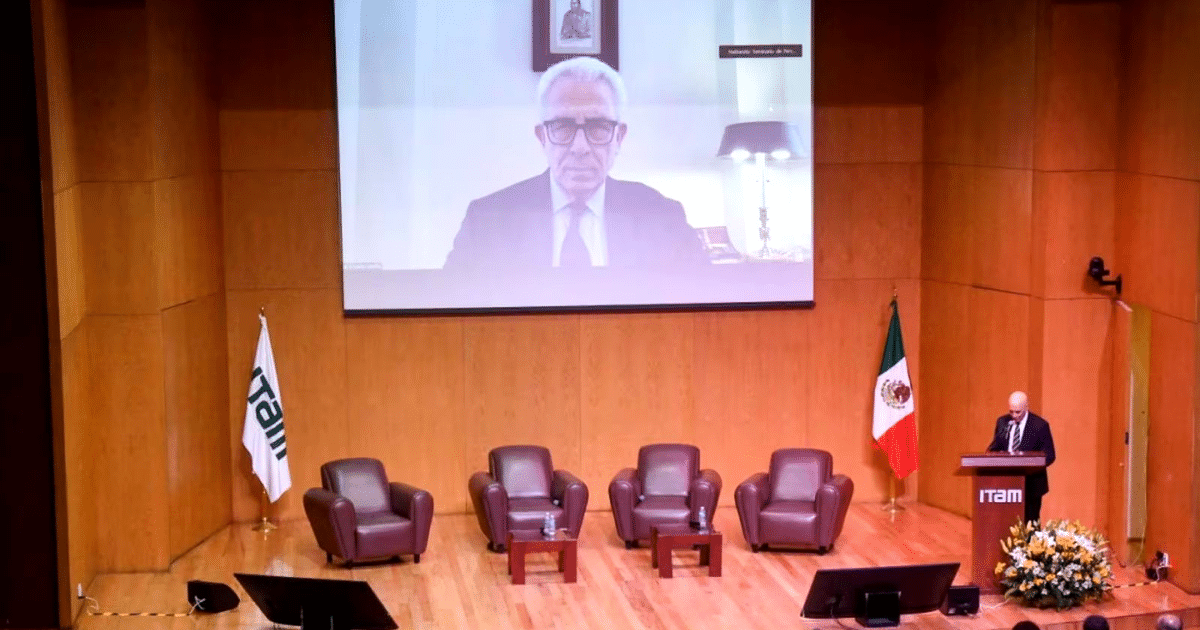 Orador en el escenario del ITAM durante el Seminario de Perspectivas Económicas 2025, con Ernesto Zedillo participando virtualmente.