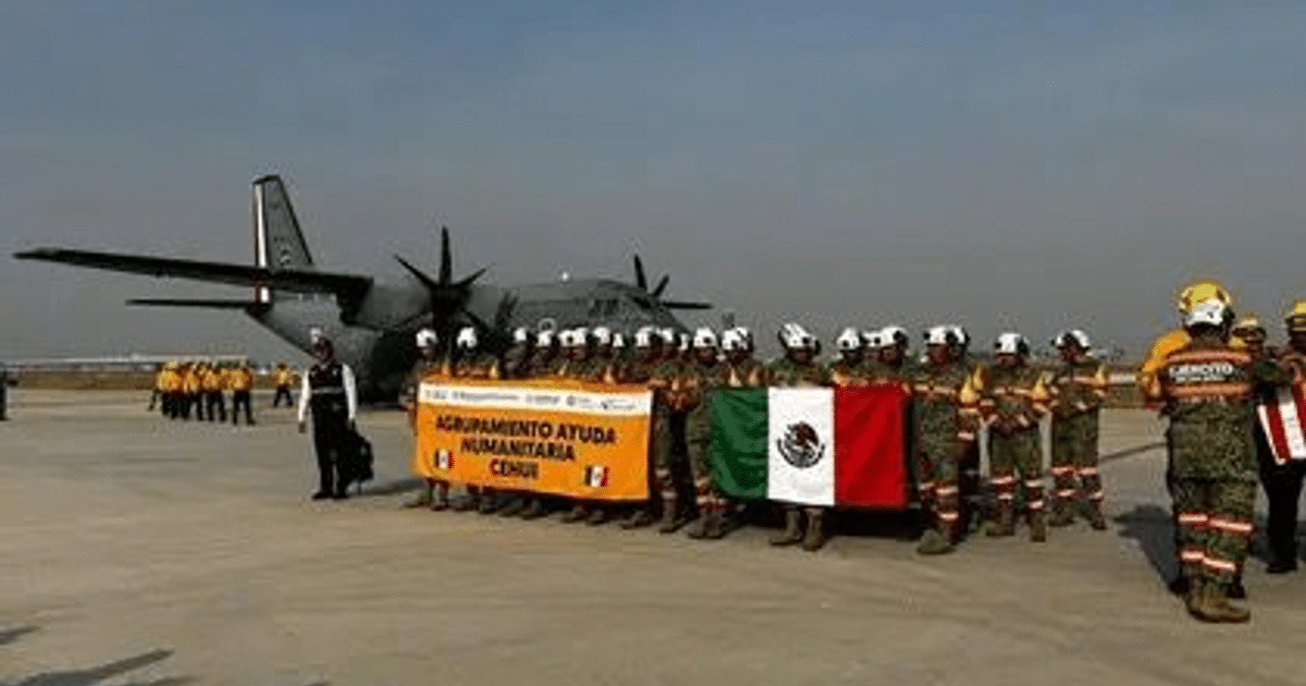 Equipo de ayuda humanitaria mexicana en aeropuerto con pancarta y bandera de México, avión de carga al fondo.