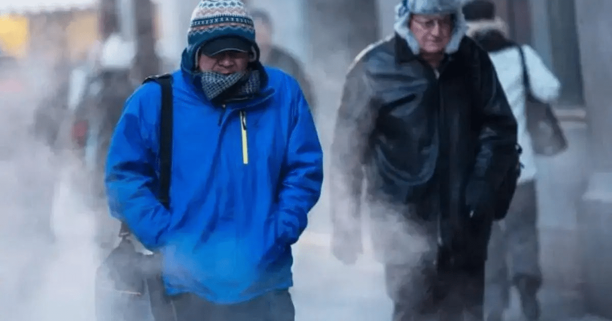 Personas caminando en una calle fría con vapor en el aire, reflejando el clima invernal en Guasave.