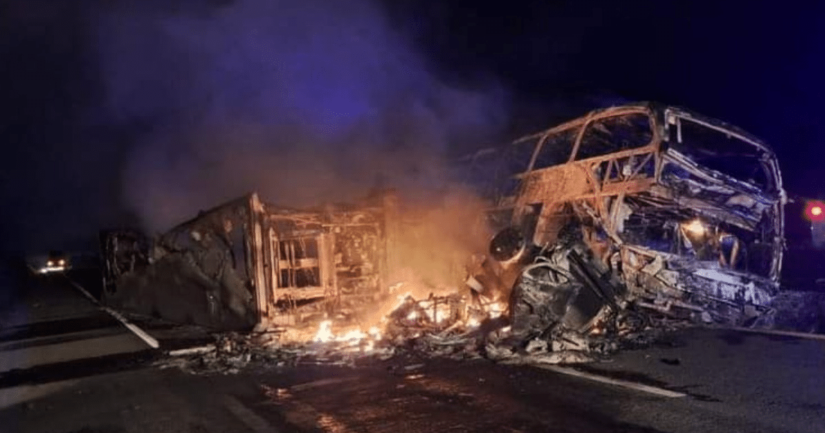 Autobús volcado y en llamas en la carretera durante la noche, relacionado con el accidente en Elota, Sinaloa.