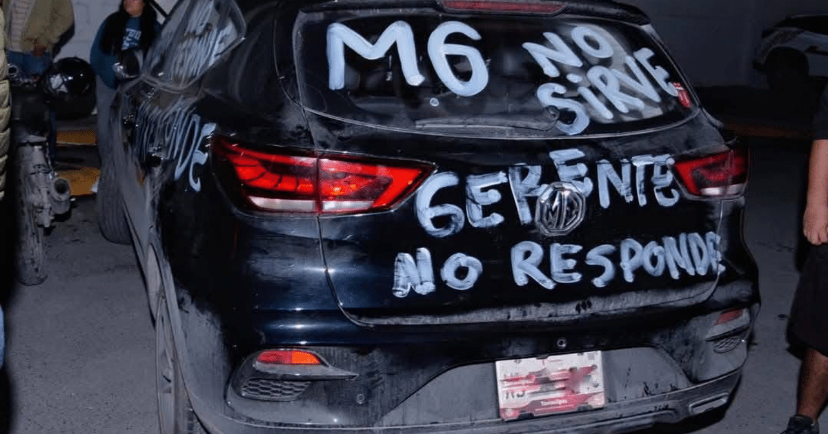 Automóvil negro con grafitis en protesta contra la agencia MG de Reynosa.