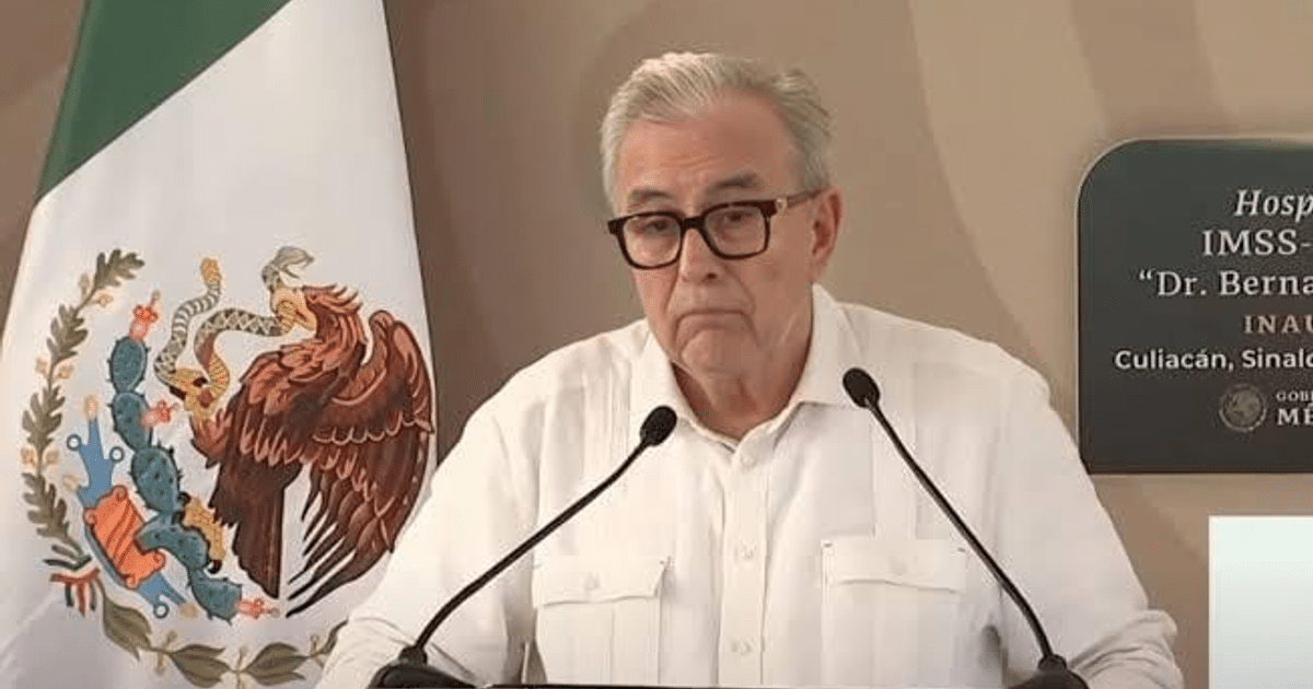 Gobernador Rubén Rocha Moya en conferencia sobre el Carnaval de Mazatlán, con bandera de México al fondo.
