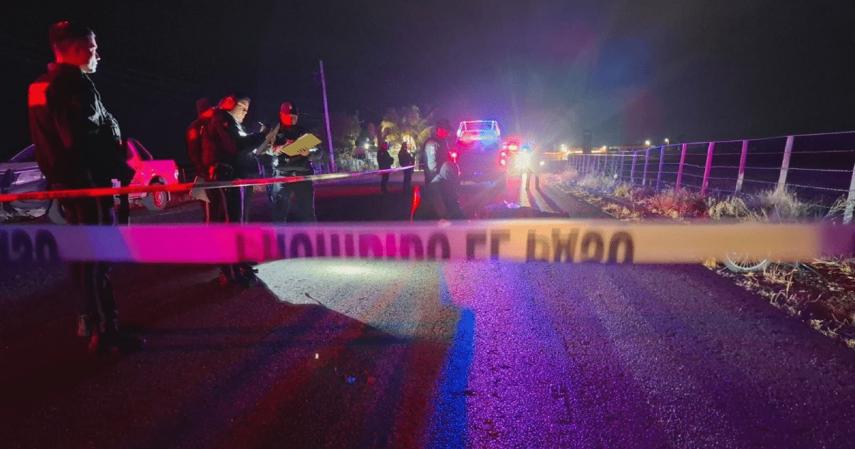 Investigación nocturna en carretera con cordón de seguridad y vehículos de emergencia.