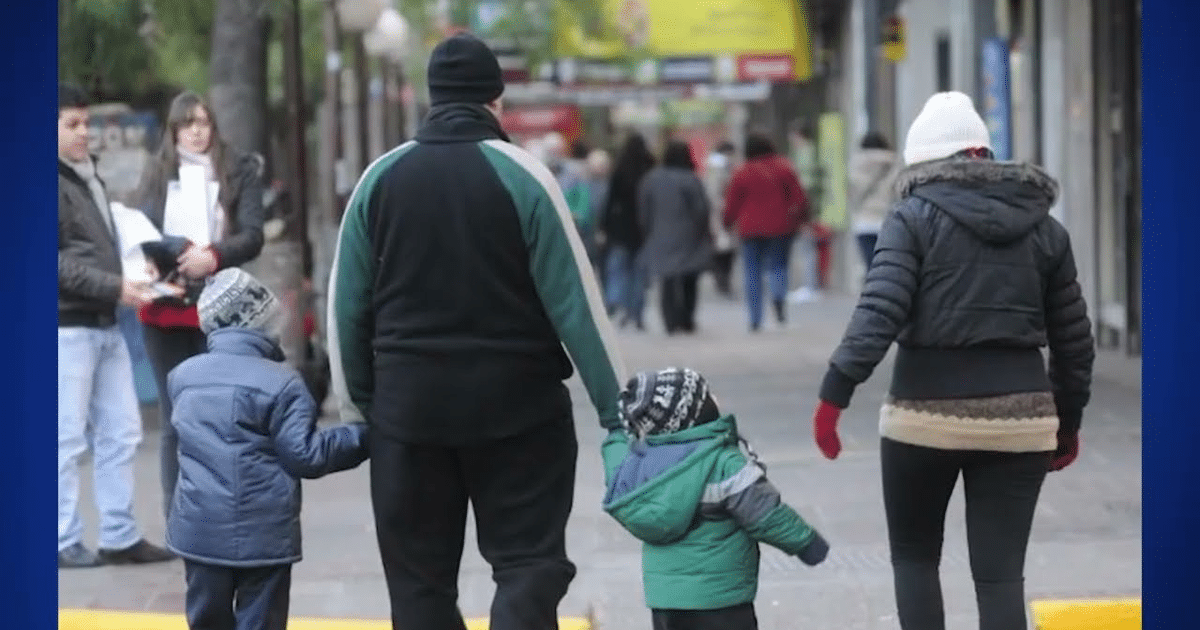 Grupo de personas caminando en una calle de Culiacán, con abrigos en un día frío.
