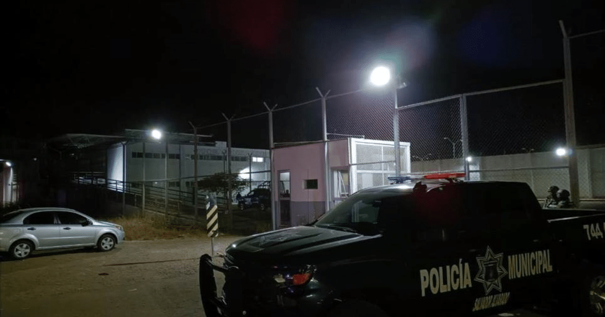 Vehículo de policía municipal en Culiacán frente a un edificio protegido durante la noche.