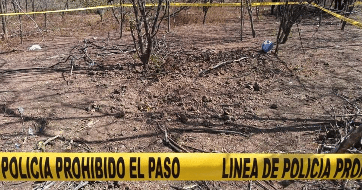 Terreno árido con cinta policial en Culiacán, sitio de fosa clandestina.