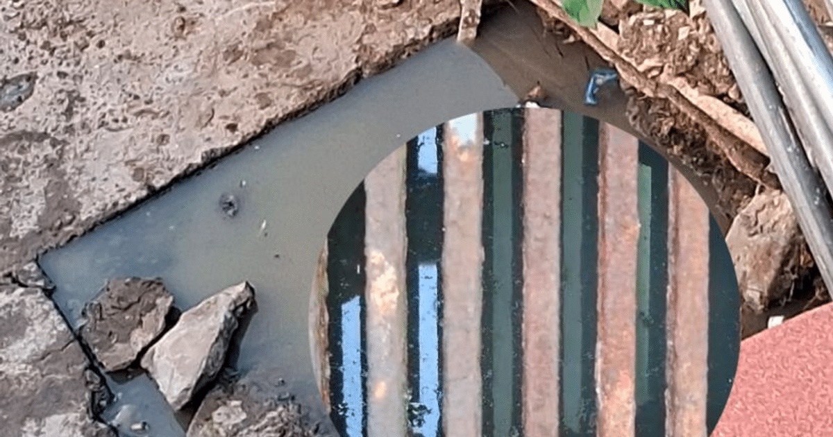 Bache con agua estancada en Benito Juárez, Mazatlán, reflejando barras verticales.