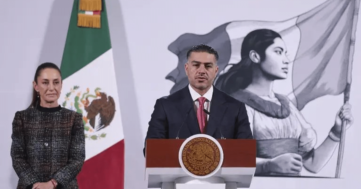Omar García Harfuch en conferencia sobre desmantelamiento de centro de videovigilancia en Culiacán, con bandera de México de fondo.