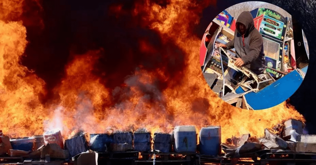 Hoguera con llamas y humo negro, persona desmantelando máquinas de juego.