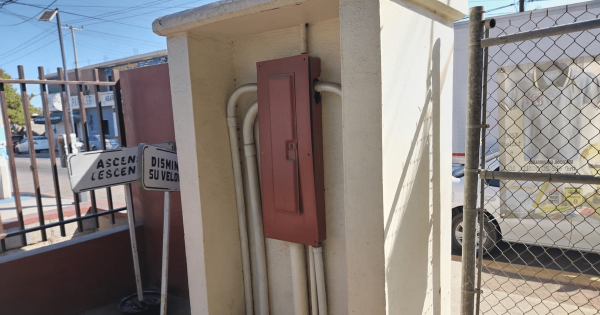 Poste con tuberías y señales de tráfico en entorno urbano, relacionado con cortes eléctricos en Sinaloa.