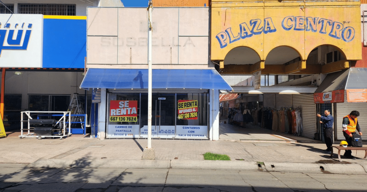 Local comercial en renta en Sinaloa con carteles de 'SE RENTA' y personas caminando por la acera.