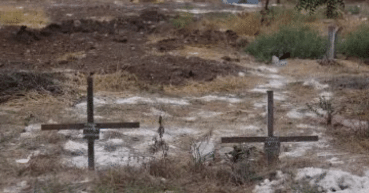 Cementerio con cruces y vegetación escasa, relacionado con la exhumación en el panteón 21 de Marzo.