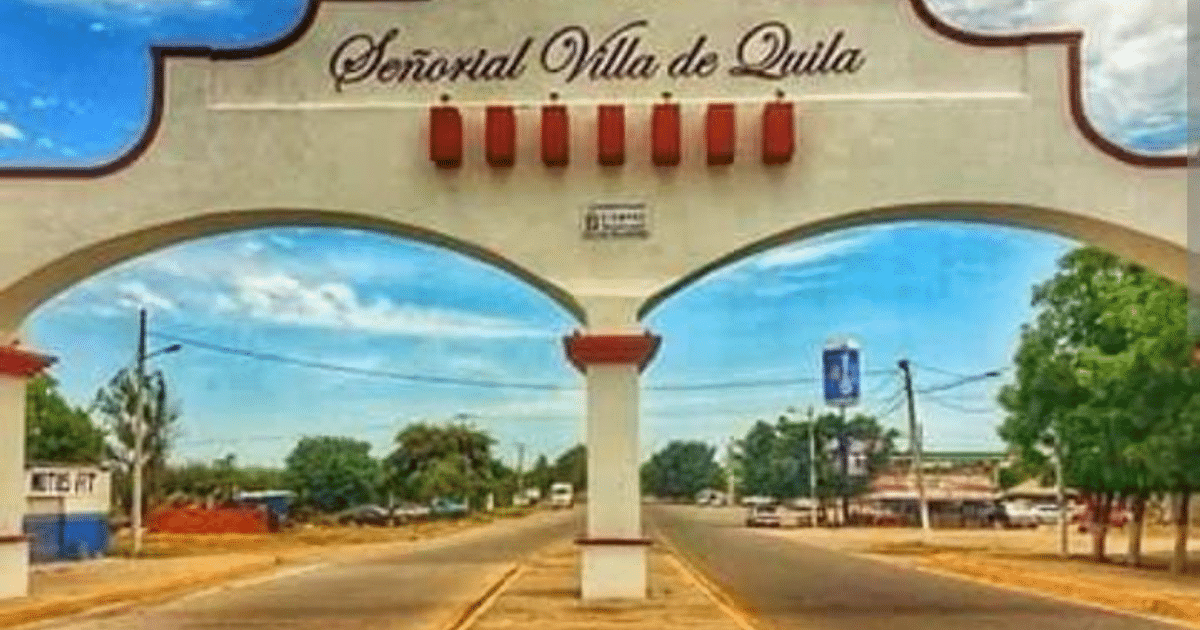 Arco de entrada a la Señorial Villa de Quila con carretera y cielo despejado