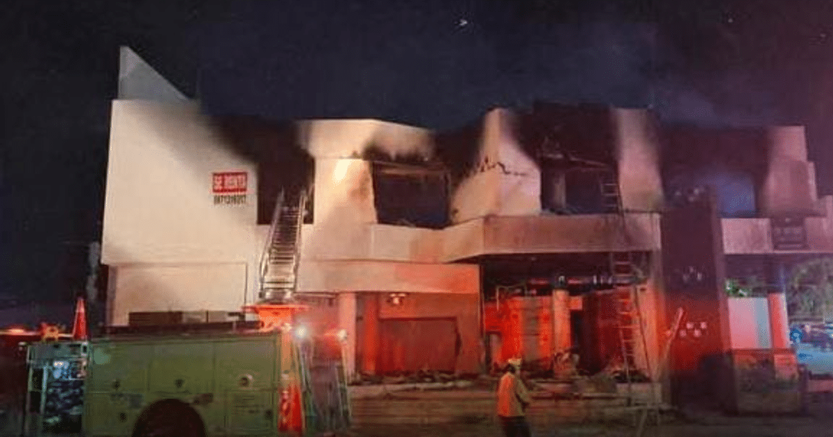 Edificio en llamas con vehículo de bomberos y trabajador de emergencia en Culiacán