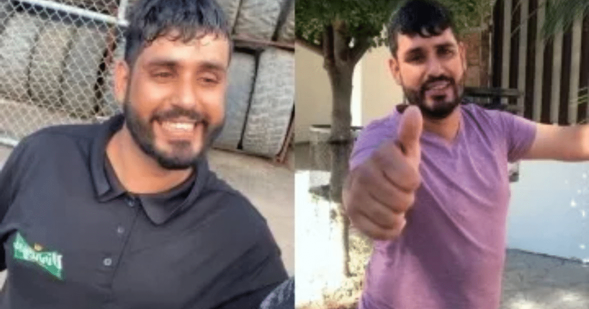 Jaimico sonriendo con camiseta negra y morada, fondo de rueda y árboles