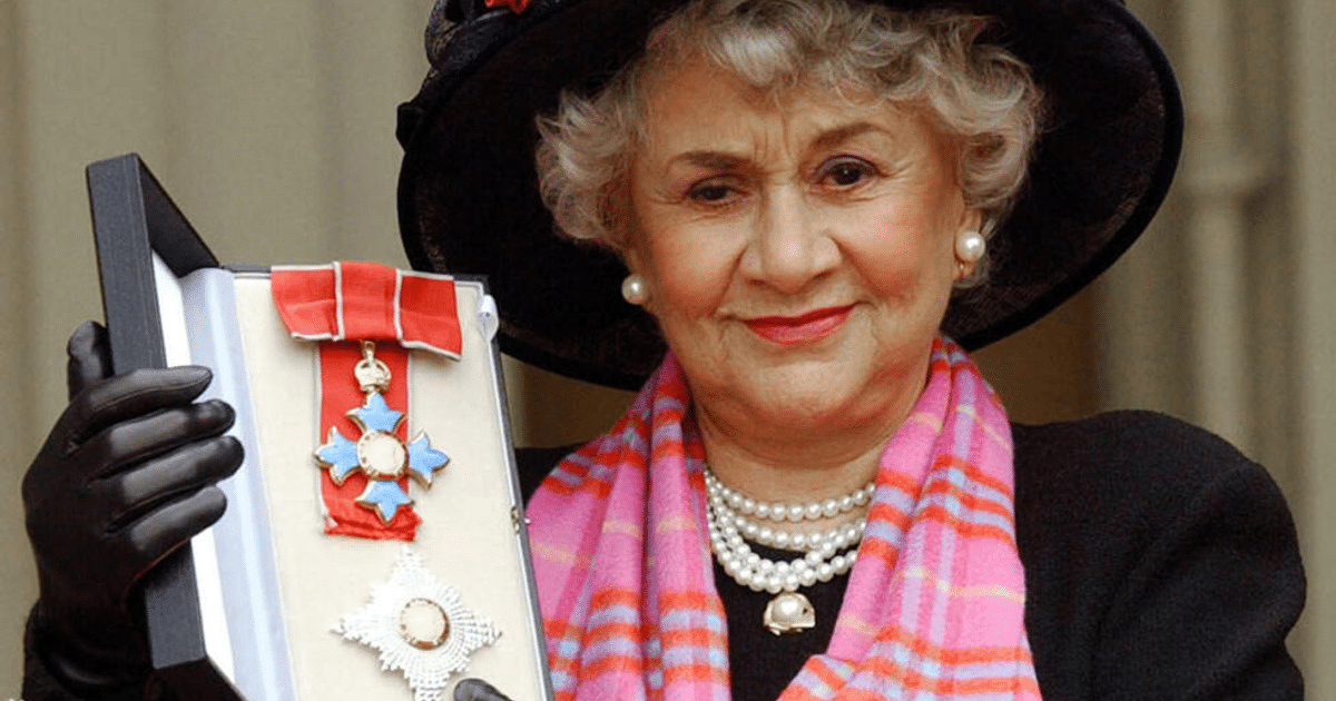 Mujer con sombrero negro sosteniendo medallas, homenaje a Joan Plowright