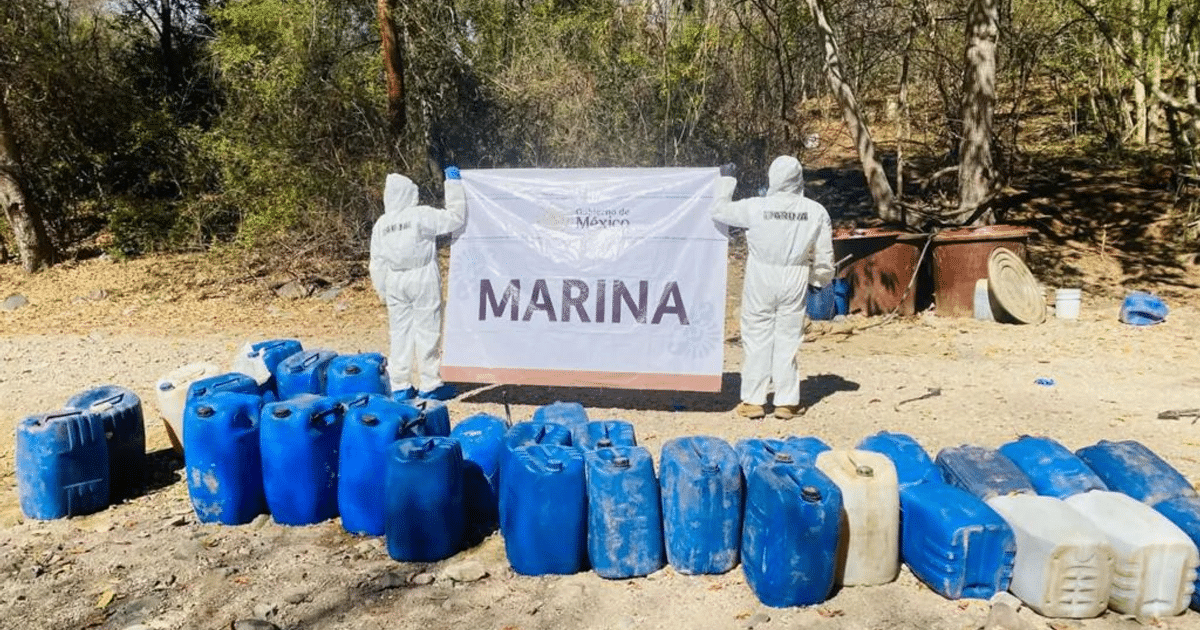 Agentes de la Marina en trajes de protección con cartel 'MARINA' y bidones azules en operativo antidrogas en Culiacán.
