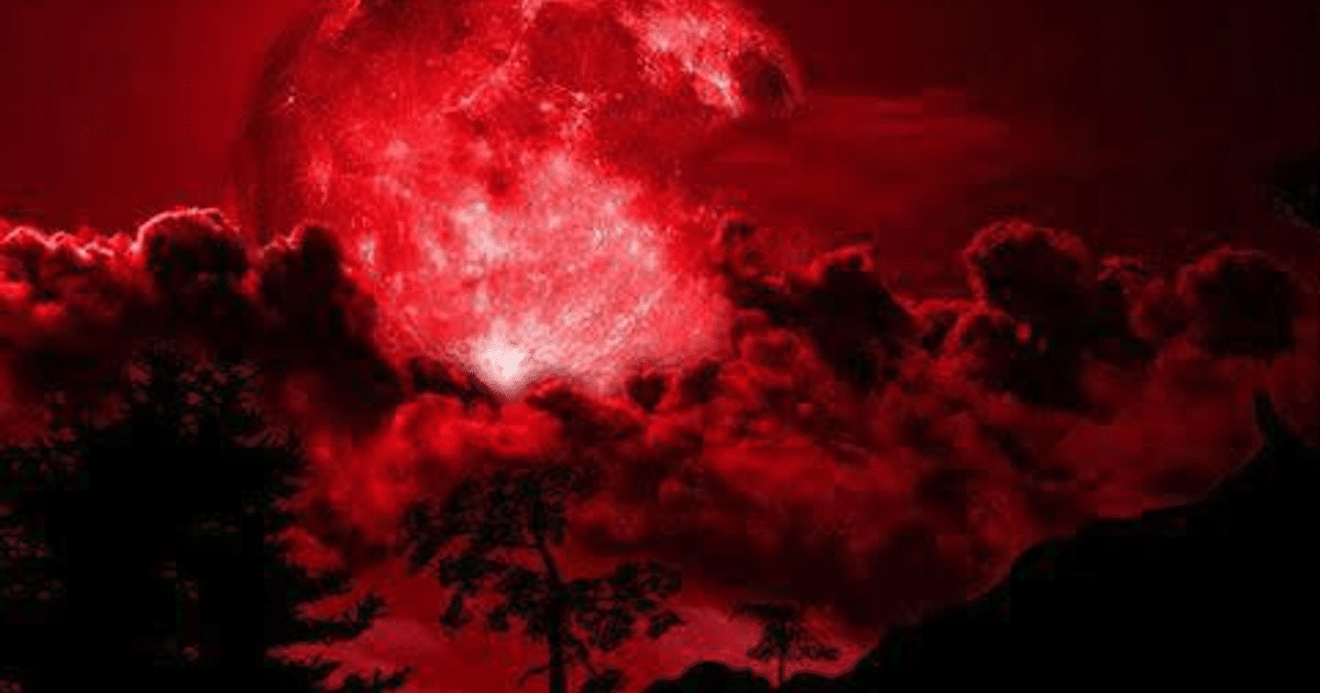 Paisaje con cielo rojo y luna de sangre durante un eclipse lunar, con siluetas de árboles en el horizonte.