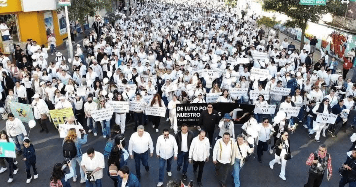 Multitud vestida de blanco en marcha pacífica en Mazatlán, sosteniendo globos y pancartas.