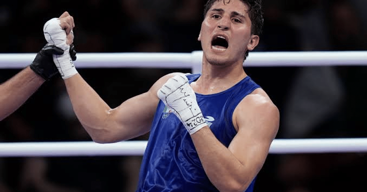 Boxeador Marco Verde celebrando victoria en el ring con puño levantado.