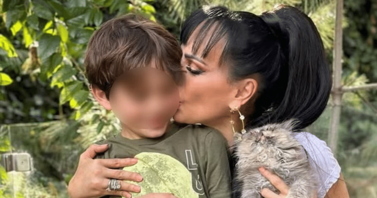 Mujer abrazando a un niño con una mascota en brazos, rodeados de plantas verdes.