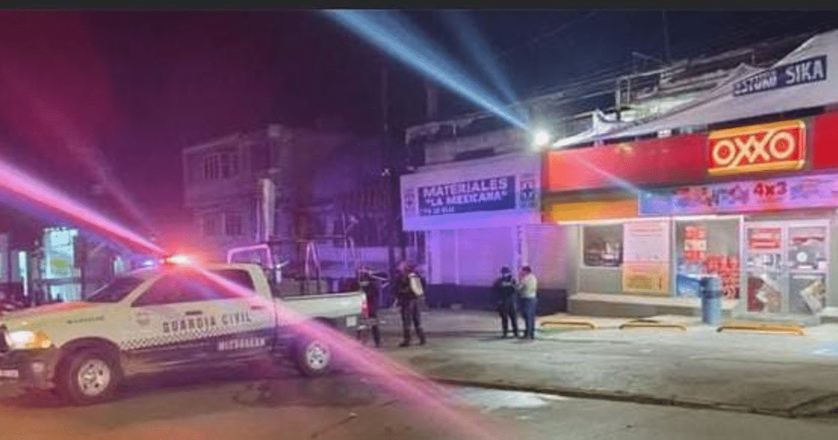 Patrulla de la Guardia Civil frente a tienda OXXO en Zamora durante la noche, con luces intermitentes y personas conversando.