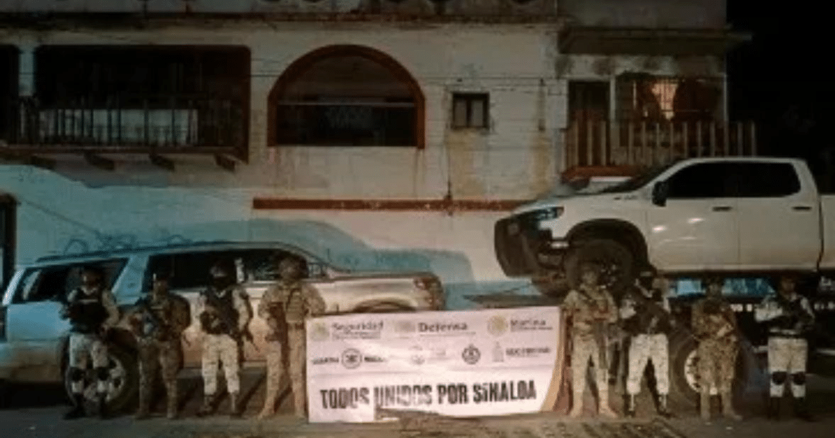 Soldados armados alineados frente a un muro con un cartel de 'TODOS UNIDOS POR SINALOA' durante un operativo nocturno en Mazatlán.