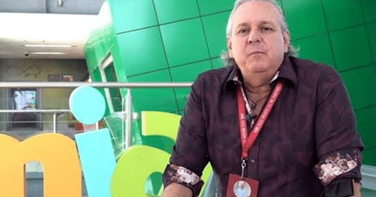 Hombre sentado frente a fondo colorido en entorno moderno