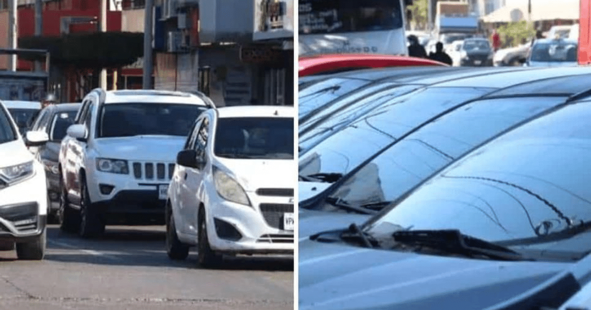 Escena de tráfico urbano en Sinaloa con vehículos y edificios al fondo, destacando un coche blanco.