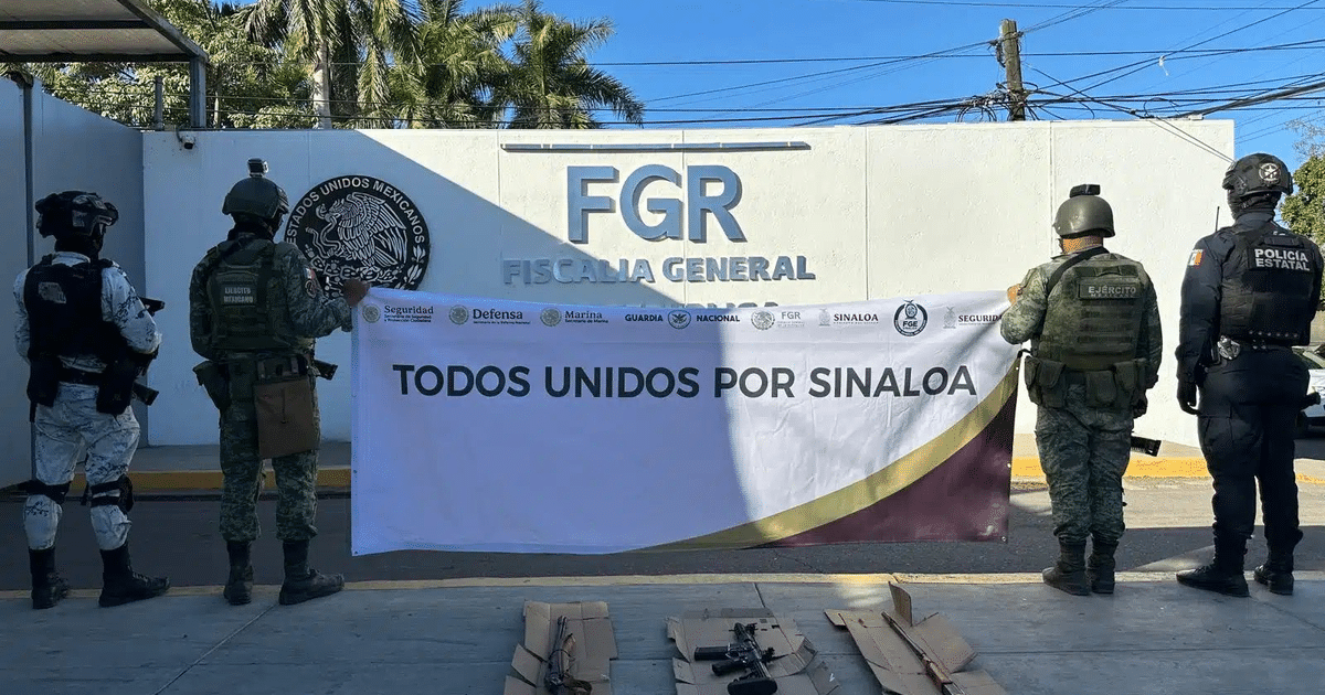 Elementos de seguridad frente a la FGR con pancarta 'TODOS UNIDOS POR SINALOA' y armas en el suelo.