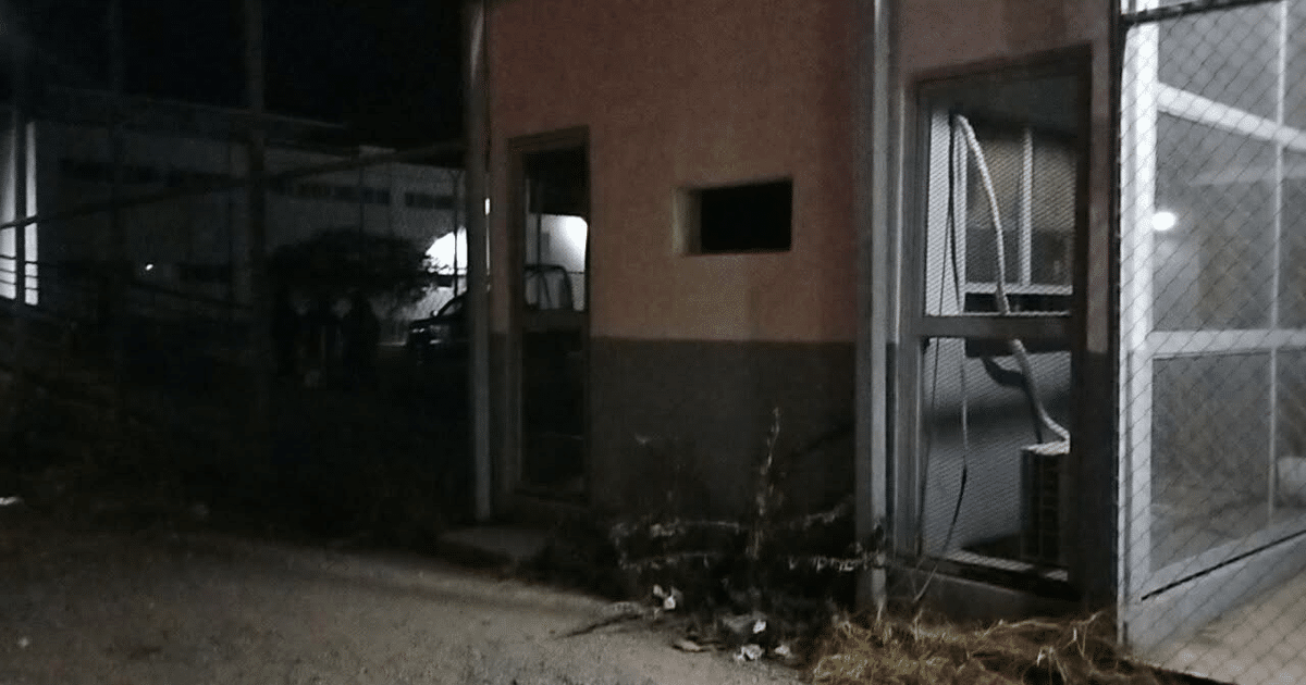 Almacén nocturno con rejas y luces de fondo, vinculado a la fuga en el penal de Angostura.