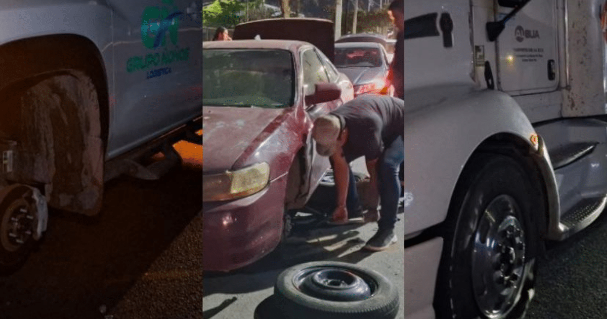 Hombre cambiando llanta de auto rojo en carretera de Culiacán, afectada por ponchallantas, con camioneta y camión al fondo.