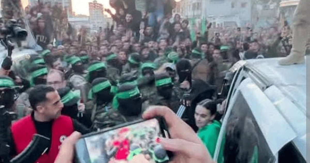 Grupo de personas con máscaras y bandas verdes en una manifestación, con un vehículo en el centro y alguien sobre su techo.