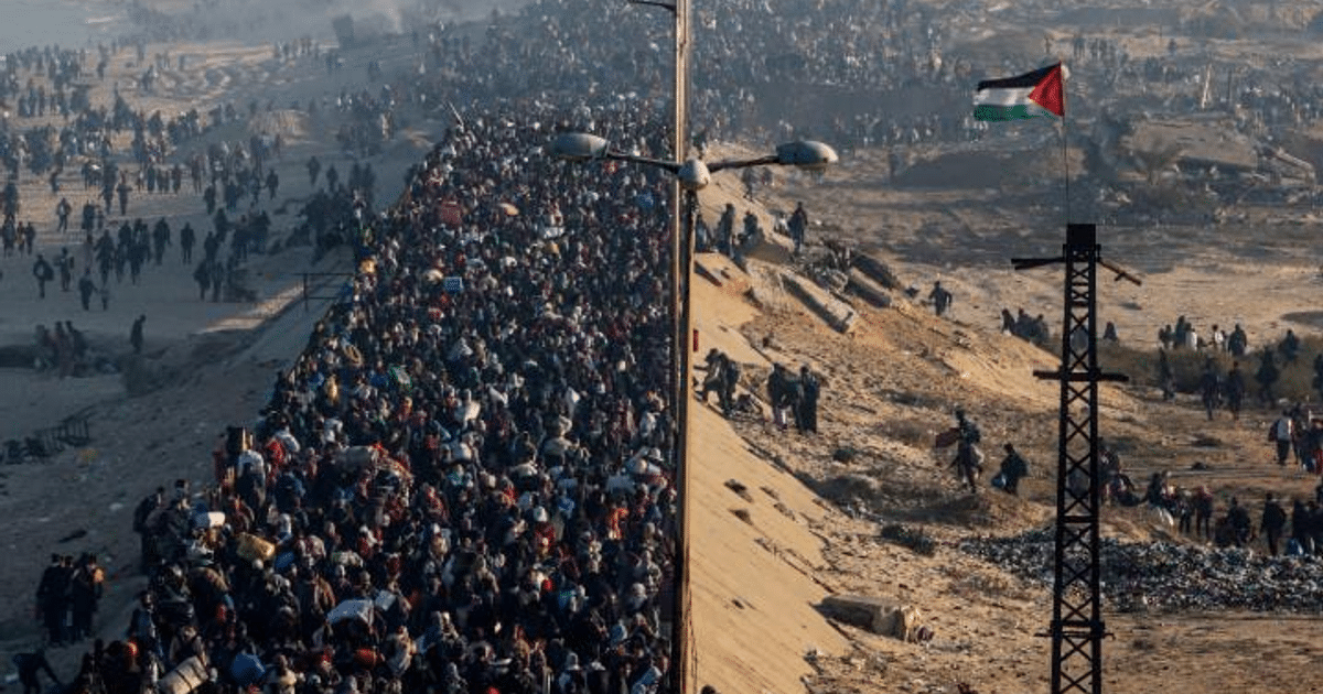 Multitud de palestinos regresando a Gaza con una bandera ondeando, simbolizando el retorno tras el conflicto.