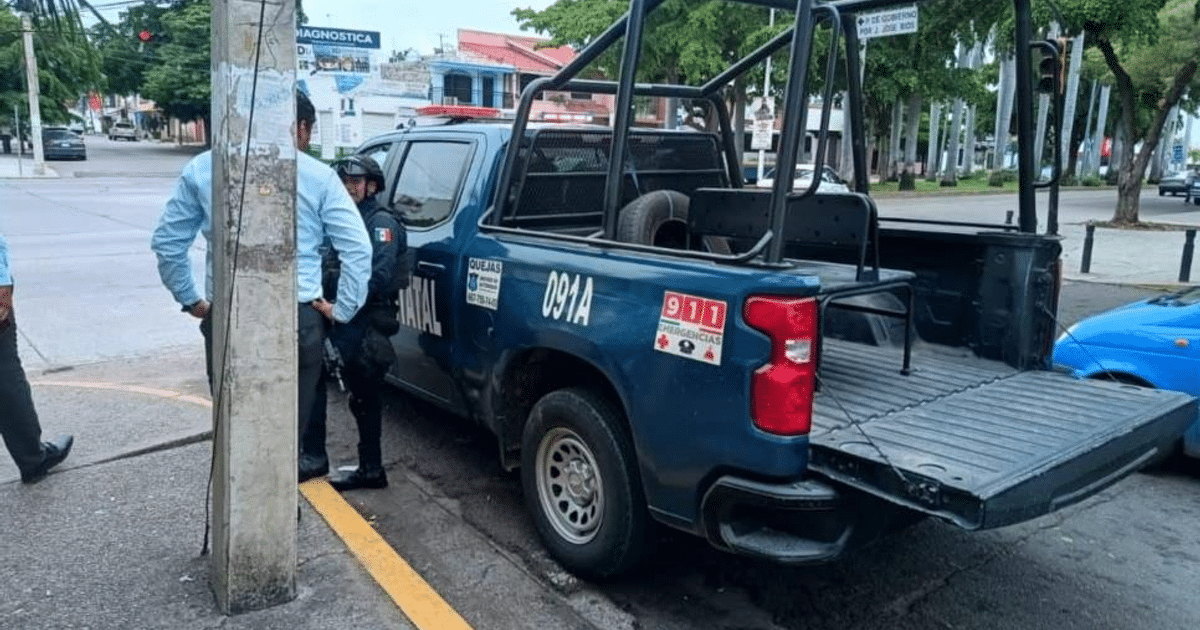 Camioneta de policía azul en Culiacán con personas alrededor, vinculada al secuestro de un exagente.