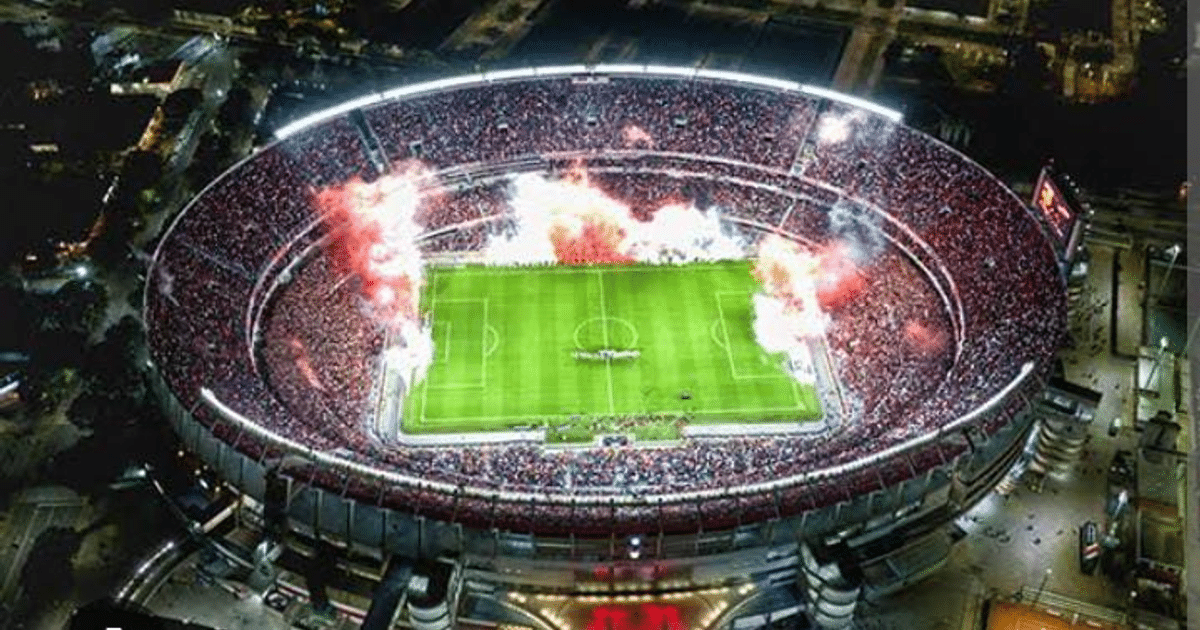 Estadio Monumental de Buenos Aires lleno de aficionados con fuegos artificiales en el cielo nocturno
