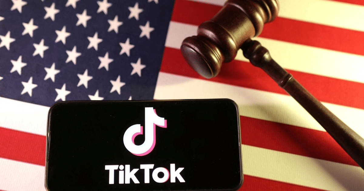 Teléfono con logotipo de TikTok sobre bandera de EE.UU. y martillo de juez, simbolizando la prohibición legal.